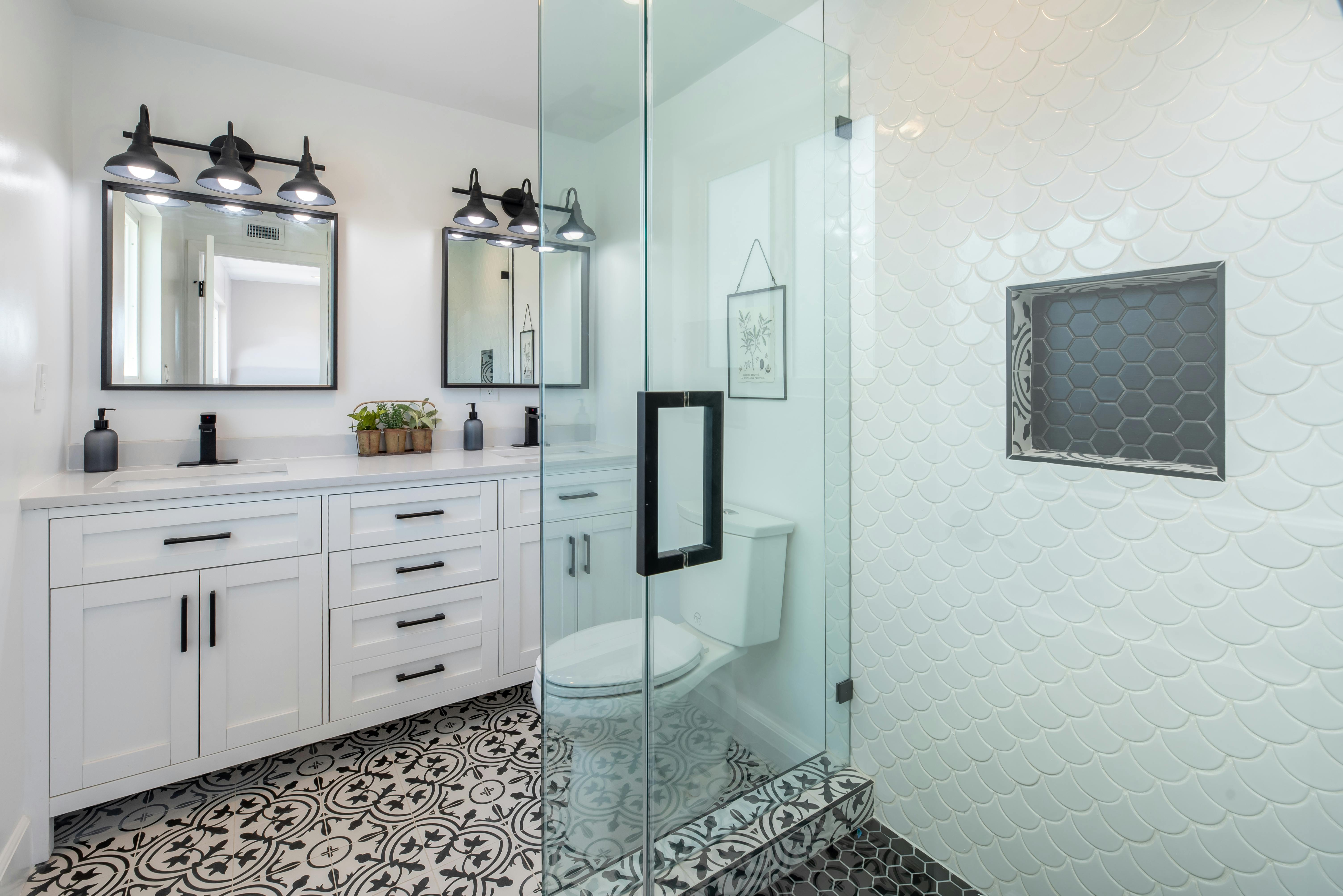 Bright white bathroom with glass shower and patterned tile floor