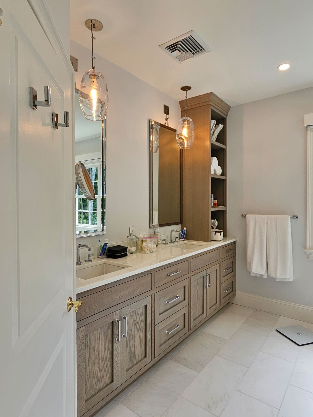 Vanity area with wood cabinets and pendant lighting